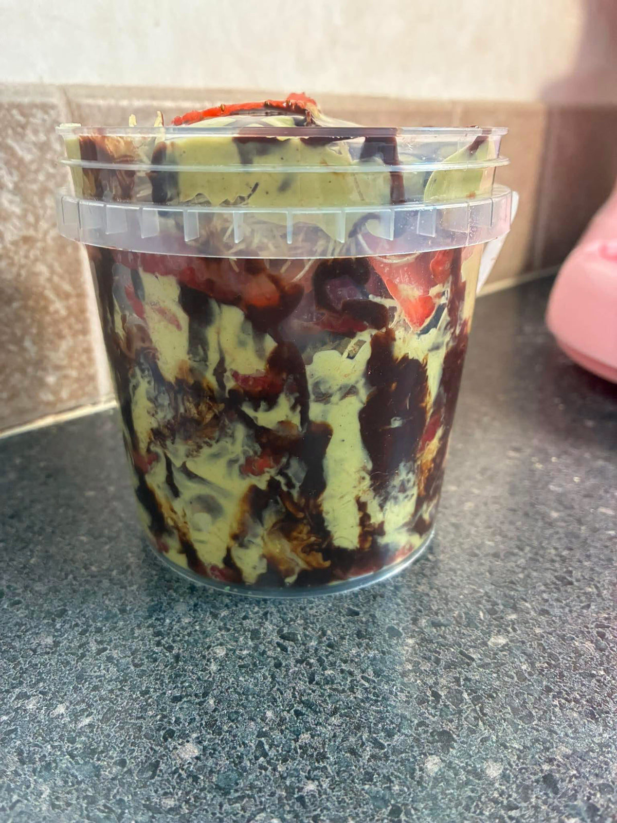 Strawberry Dubai Chocolate Overload Dessert Bucket in a clear container showing rich chocolate and strawberry swirls